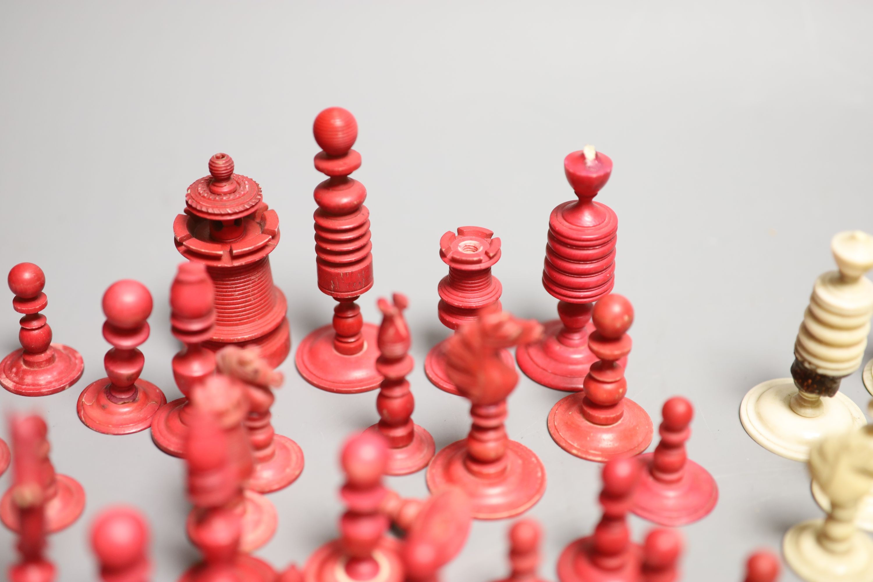 A set of 19th century red stained and natural bone chess pieces and a collection of etched mother of pearl bezique counters